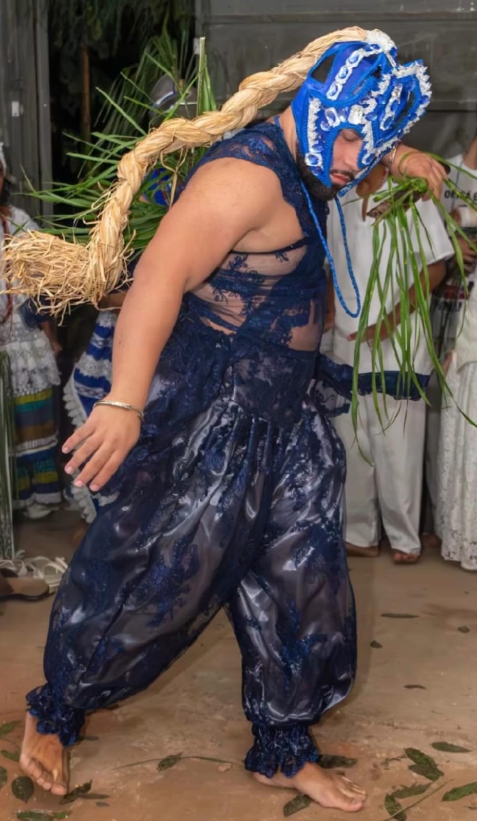 Orixá em vestimenta azul com palha da costa em saída ritual