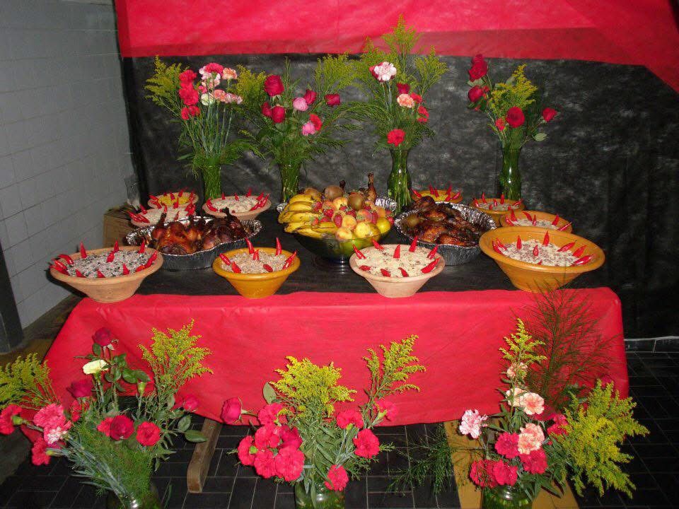 Mesa de oferendas com flores e iguarias